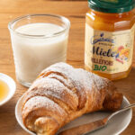 Vasetto di miele millefiori Apicoltura Gardin con latte e croissant a colazione