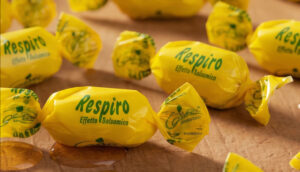 Caramelle balsamiche Respiro Apicoltura Gardin negli incarti gialli su un piano di legno